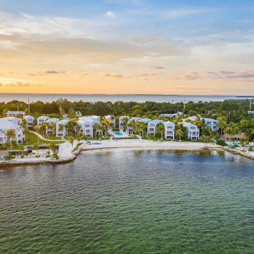 A coastal residential area with waterfront homes and a serene sunset sky.